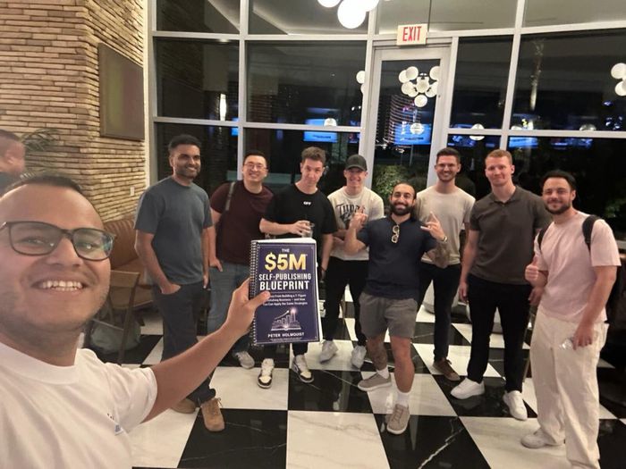 DPE members holding The $5M Self-Publishing Blueprint at the Las Vegas mastermind